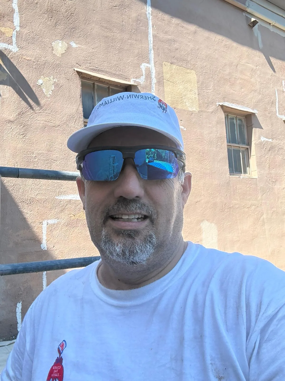 Yamil Lopez, owner of A.Y.L. Painting, on a job site in front of a masonry building being prepared for paint.